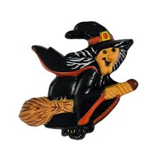 a black and orange witch riding on a broom