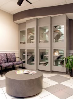 a room with two chairs and a round table in it that is surrounded by glass doors