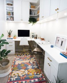 a home office with white cabinets and a rug