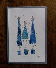 three blue christmas trees with stars on them