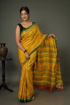 The auspicious colors make this handwoven Gachi Tussar yellow saree the perfect wedding or reception wear. The woodblock prints are a testimony of the works of skilled artisans. Its elegance makes it the go-to saree for special occasions. At Ramdhanu Ethnic, we call it a timeless fashion. You can conquer any adversity by draping this yellow saree. Remember, the essence of it hasn't changed and the charm of the fabric still remains.   What makes this saree special is the almost magical process of weaving it. The history of Tussar silk is a beautiful chapter in the history of Indian textiles. The process is much more complex and involves many unique tools that look primitive but work like magic. Tussar silk shares the history with the raw silk and is rooted in medieval times. In Sanskrit, it Luxury Tussar Silk Saree With Tilla, Yellow Handloom Pre-draped Saree For Navratri, Yellow Slub Silk Anarkali Traditional Wear, Yellow Handloom Pre-draped Saree For Wedding, Yellow Tussar Silk Pre-draped Saree For Diwali, Festive Yellow Tussar Silk Pre-draped Saree, Yellow Semi-stitched Cotton Silk Saree, Traditional Yellow Raw Silk Pre-draped Saree, Wedding Chanderi Pre-draped Saree With Block Print