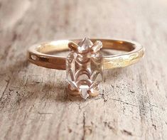 a close up of a ring on a wooden surface with a stone in the middle