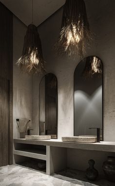 a bathroom with two sinks and three lights hanging from it's ceiling above them