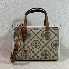 Price Is Firm. In Brand New Never Been Carried Condition. Price Is Firm. In Brand New Never Been Carried Condition. T Monogram Jacquard Mini Tote By Tory Burch. This Bag Is Made Of Genuine Leather Trim And Beige Jacquard With Hazel Logo Dimensions: 7.5” Wide X 6” Tall Center X 3.25" Deep. Handle 3" Drop Long Leather Strap Is Adjustable And Detachable Strap And Handle Are In Tan Leather Snap On Magnetic Button Top Closure Interior: Single Compartment One Slip Card Pocket Beige Microfiber Lining. White Monogram Canvas Bag For Formal Occasions, Tan Monogram Bag, Luxury White Bag With Monogram Print, White Monogram Print Bag For Everyday Use, Beige Monogram Canvas Bag With Monogram Print, Elegant Tan Monogram Bag, Hazel Logo, T Monogram, Tory Burch Bag