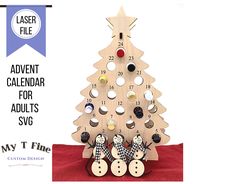 a wooden christmas tree with buttons on it and a sign that says laser file the tipsy tree is 5'3