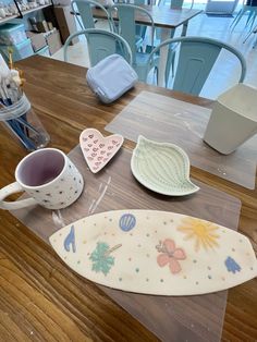 a table topped with plates and cups on top of a wooden table