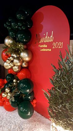 a christmas display in front of a red heart with gold and green ornaments on it