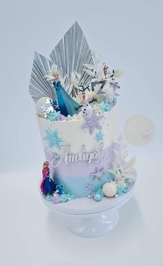 a frozen princess themed birthday cake with frosting and decorations on it's side