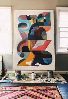 an abstract painting is being worked on in a studio