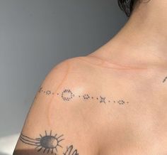 the back of a woman's shoulder with tattoos on it