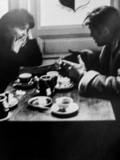 two men sitting at a table with food in front of them