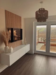 a living room filled with furniture and a flat screen tv on top of a wooden wall