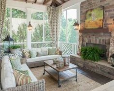 a living room filled with furniture and a fire place in front of a window on top of a wooden floor