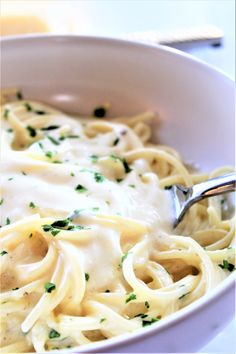 a white bowl filled with pasta and sauce