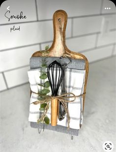 a kitchen utensil holder with a wire whisk and leafy greens