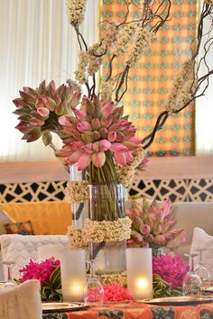 a vase with flowers and candles on a table