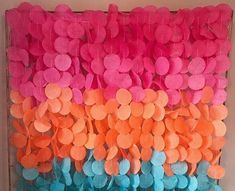 the wall is decorated with pink, orange and blue pom poms