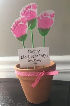 some pink flowers in a pot with a happy mother's day sign on it