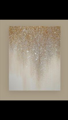 an abstract painting with gold and white paint on the wall in front of a beige background