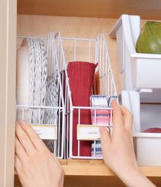 two hands reaching for items in a dishwasher