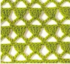 the green crochet pattern is made up of small triangles and has been stitched together