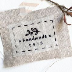 a piece of fabric with the words handmade love is hanging from it's side