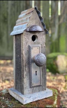 a birdhouse with a key on it in the woods