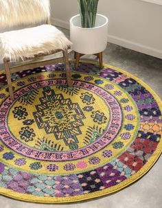 a round rug with an ornate design on the floor next to a chair and potted plant