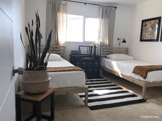 two beds in a room with black and white rugs