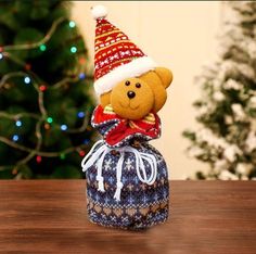 a teddy bear wearing a christmas hat and scarf sitting on top of a blue bag