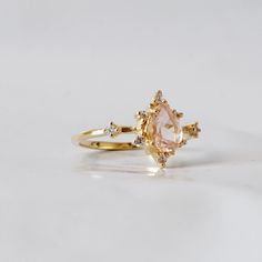 This ring is an elegant beauty for the ages. A peachy morganite set 14K solid gold. Definitely a timeless classic. Available in yellow gold vermeil, rose gold, and silver. Material: - 14K solid gold - Natural Morganite 7x5mm - Round CZs **This item is made to order, please allow 1-2 weeks for your order to be shipped. Shipping: Domestic: Ship via USPS priority mail International: $15 for international standard shipping. $10 to Canada. Online Return Policy: Due to the made to order nature, this r Delicate Morganite Rings With Rose Cut Diamonds, Fine Jewelry Morganite Rings With Rose Cut Diamonds, Fine Jewelry Rings With Morganite And Rose Cut Diamonds, Fine Jewelry Rings With Rose Cut Diamonds And Morganite, Heirloom Morganite Diamond Ring For Formal Occasions, Elegant Pink Topaz Ring In 14k Gold, Classic Morganite Diamond Ring In Yellow Gold, Heirloom Morganite Diamond Ring With Gemstone, Morganite Pear-shaped Fine Jewelry Ring