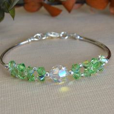 Made with 4mm crystals, 8mm clear swarovski crystal and silver bars Beautiful Beaded Earring, Peridot Crystal, Beaded Earring, Bracelets Design, Swarovski Crystal Bracelet, Beaded Jewelry Tutorials, Crystal Bangle, Memory Wire Bracelets, Jewellery Ideas