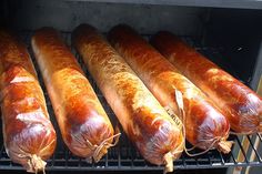 several sausages are being cooked on the grill