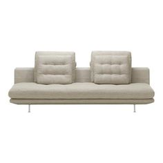 a white couch sitting on top of a metal frame with two pillows in front of it