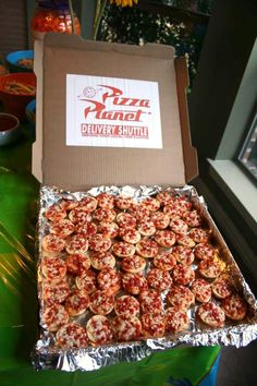 a pizza box filled with mini pizzas on top of tin foil