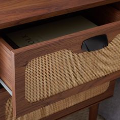 a close up of a wooden drawer with a book in the bottom and an ipod inside