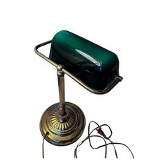 a green and black lamp sitting on top of a metal stand next to a wire