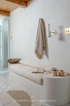 a white couch sitting next to a wall mounted coat rack on a wooden ceiling above it