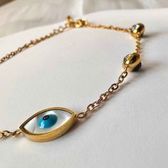 This dainty, stylish Nazar bracelet is the perfect accessory to protect yourself! Crafted with a shimmering zircon crystal and evil eye for warding off bad luck, you'll be lookin' and feelin' fly - all while keeping bad vibes out! 😉 ✓ 6.5-8 inch / 16.5-20.3cm *adjustable chain ✓ 18K Gold Plated Stainless Steel✓ Waterproof: does not change color with water exposure Gold Bracelets With Diamond Eyes As A Gift, Metal Evil Eye Bracelet For Gift, Evil Eye Metal Bracelet Gift, Gold Charm Bracelet With Evil Eye, Metal Charm Bracelet With Evil Eye For Gift, Metal Charm Bracelet With Evil Eye, Evil Eye Metal Charm Bracelet, Evil Eye, Color Change