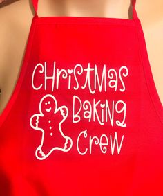 a red apron that says christmas baking crew on the front, and an image of a gingerbread