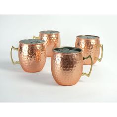 three copper mugs with handles are sitting side by side