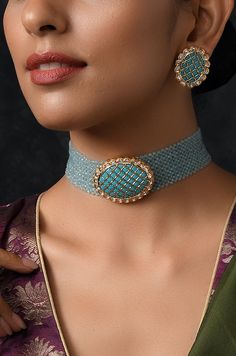 Turquoise gold tone kundan stones choker necklace with earrings. Necklace Choker Length - 14 inches Closure - Adjustable dori Earrings Size - 2.5 cm Style Tip - This pretty necklace is sure to take your wedding dressing game a notch higher with much ease. We love to see this one on rich chiffon sarees or classic black angrakha kurtas. This stunner of a necklace set is meant for royalty and is sure to fetch you compliments in plenty. Handcrafted in Jammu and Kashmir Paisley Pop travels the depths Turquoise Kundan Jewelry With Tilla Details, Turquoise Kundan Temple Jewelry, Traditional Turquoise Choker Jewelry, Handmade Turquoise Kundan Jewelry, Reception Meenakari Choker Jewelry, Turquoise Kundan Jewelry With Stone Work, Turquoise Kundan Chandbali Jewelry, Bollywood Blue Jewelry With Zari Work, Blue Bollywood Jewelry With Zari Work