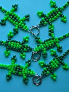 green beads are arranged in the shape of an ornament on a blue surface