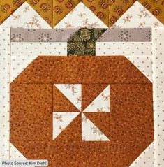 an orange and white patchwork quilt on top of a table