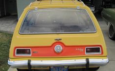 an orange and yellow car parked in front of a house