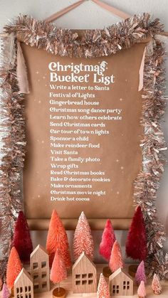 the christmas bucket list is displayed in front of small wooden houses and tinsel trees