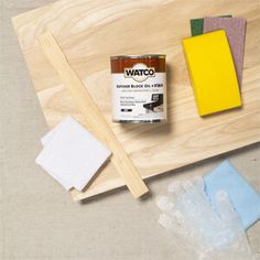 some paint and sponges are sitting on a cutting board