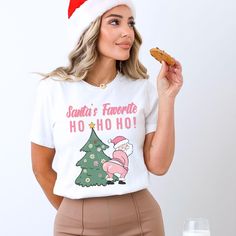 Dive into the festive spirit with our Pink Santa's Favorite Ho Ho Ho t-shirt, perfect for spreading holiday cheer in style. This Christmas shirt is not just another Santa shirt; it's a fun and quirky addition to your seasonal wardrobe. Ideal for Christmas parties or casual wear, this funny Christmas tee is a playful nod to Santa's favorite catchphrase. The design of this holiday shirt featuring 'Ho Ho Ho' in a whimsical font is sure to bring smiles wherever you go. Embrace the joy of the season with this favorite ho shirt, radiating merriment with every 'Ho' displayed proudly. Make a statement and celebrate the holidays with this Ho Ho Ho shirt that captures the essence of Christmas in a light-hearted and amusing way. Bella and Canvas This classic unisex jersey short sleeve tee fits like a Holiday White Pre-shrunk T-shirt, Fun White T-shirt For Holiday, Fun Christmas Holiday T-shirt, Santas Favorite Ho, Santa Tee, Whimsical Fonts, Christmas Party Shirt, Seasonal Wardrobe, Christmas Party Shirts