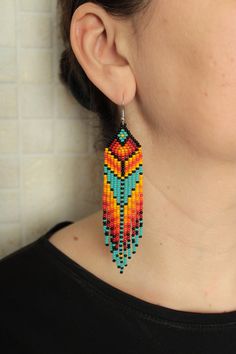 a close up of a person wearing some kind of earring with beads on it