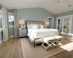 a bedroom with a large bed and white furniture